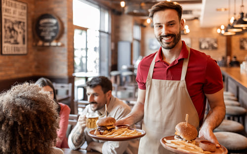 Employé en restauration rapide servant des clients dans un restaurant en France